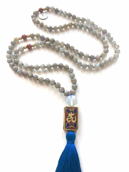 Labradorite mala in an S curve with a Tibetan inlaid Om pendant and a blue silk tassel
