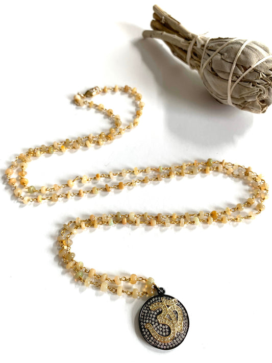Ethiopian opal rosary chain necklace in an S curve with a round pave Om medallion, a sage bundle above