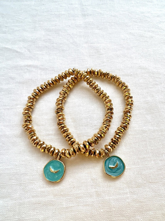 Two Earth Angel gold hematite stretch bracelets, each with an aqua enamel and gold angel wings charm