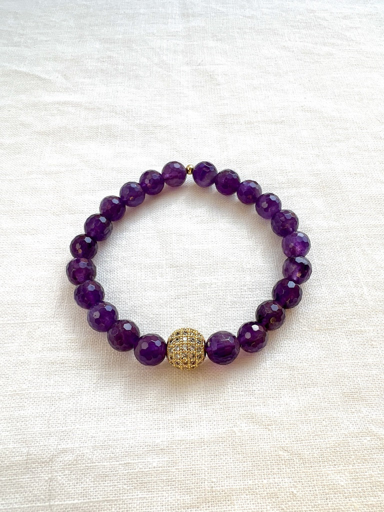 Inner Vision faceted amethyst stretch bracelet with a gold pave cubic zirconia bead on cream linen