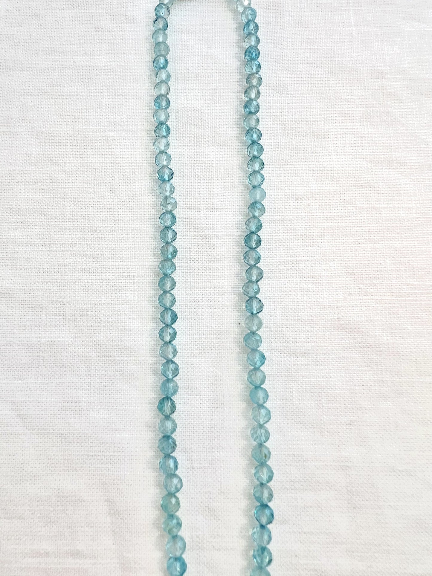Close view of the hand strung 4mm faceted blue topaz beads on a gold filled choker necklace