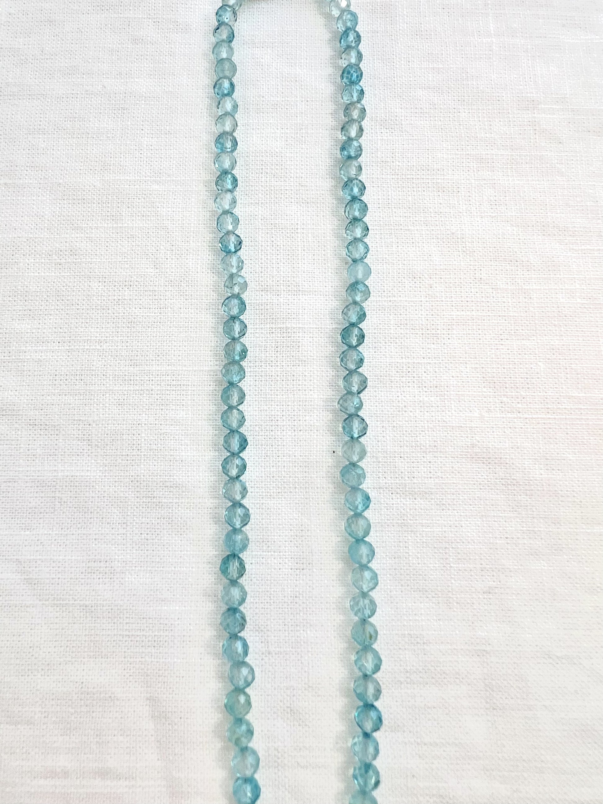 Close view of the hand strung 4mm faceted blue topaz beads on a gold filled choker necklace