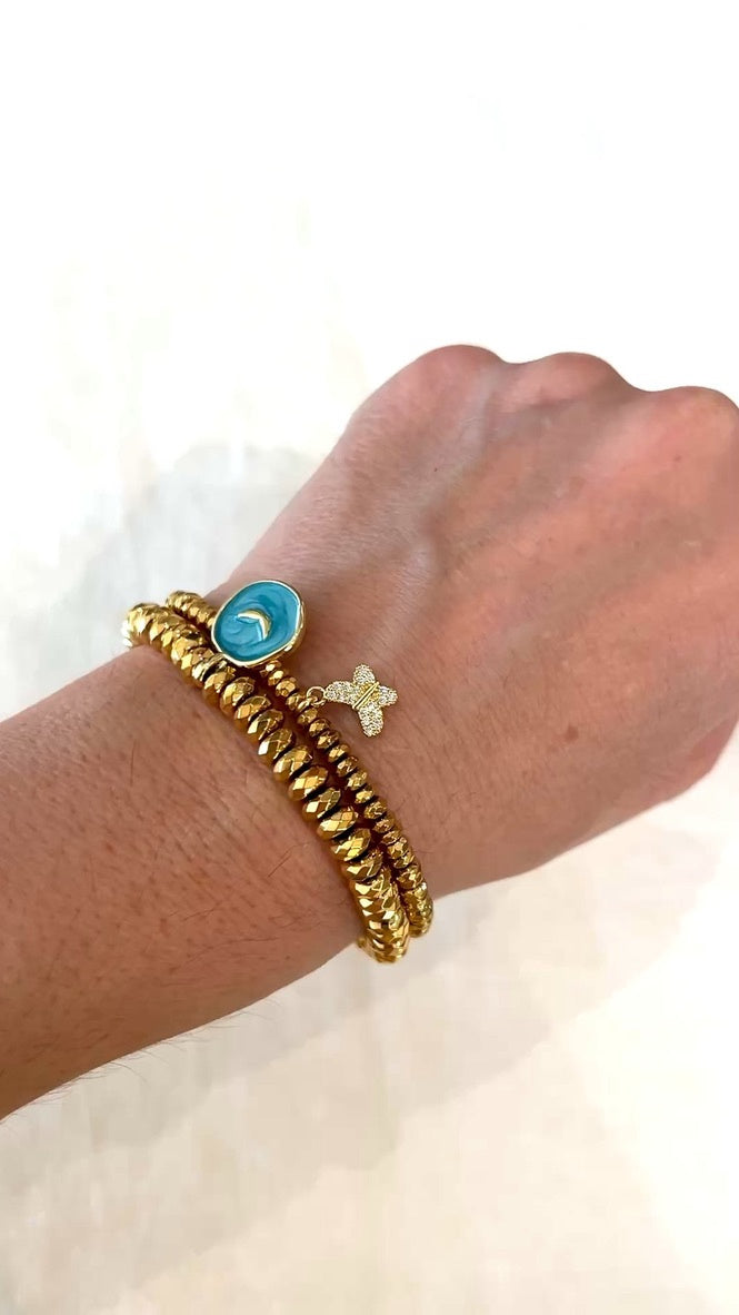Earth Angel bracelet worn on the wrist, stacked with the Butterfly Kisses gold hematite bracelet and its pave butterfly charm
