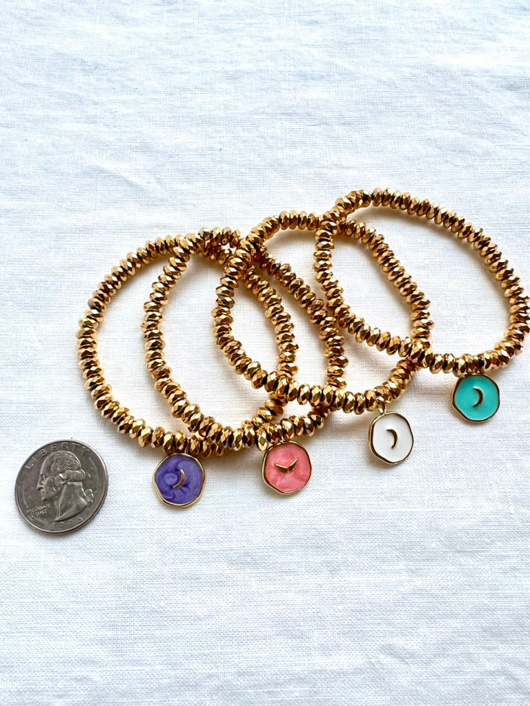 Four enamel moon charm bracelets shown beside a quarter for scale, 14mm enamel charms on 6x4mm gold plated hematite beads