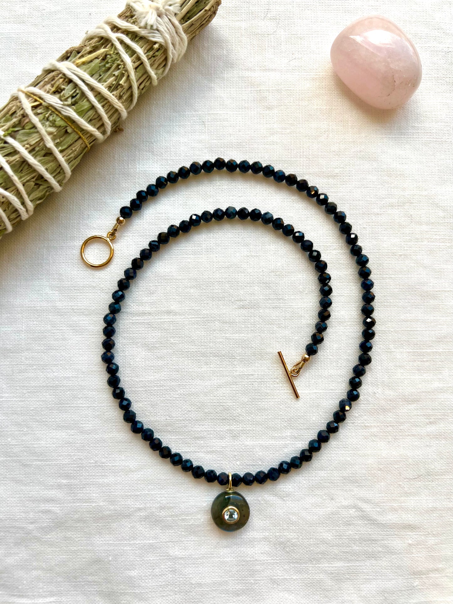 Strand of 4mm faceted blue sapphire beads with a round labradorite pendant