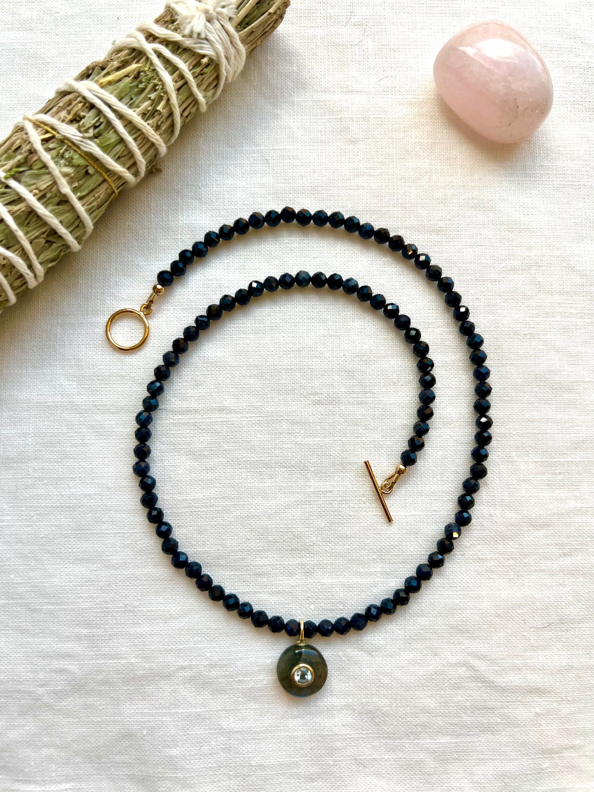 Strand of 4mm faceted blue sapphire beads with a round labradorite pendant
