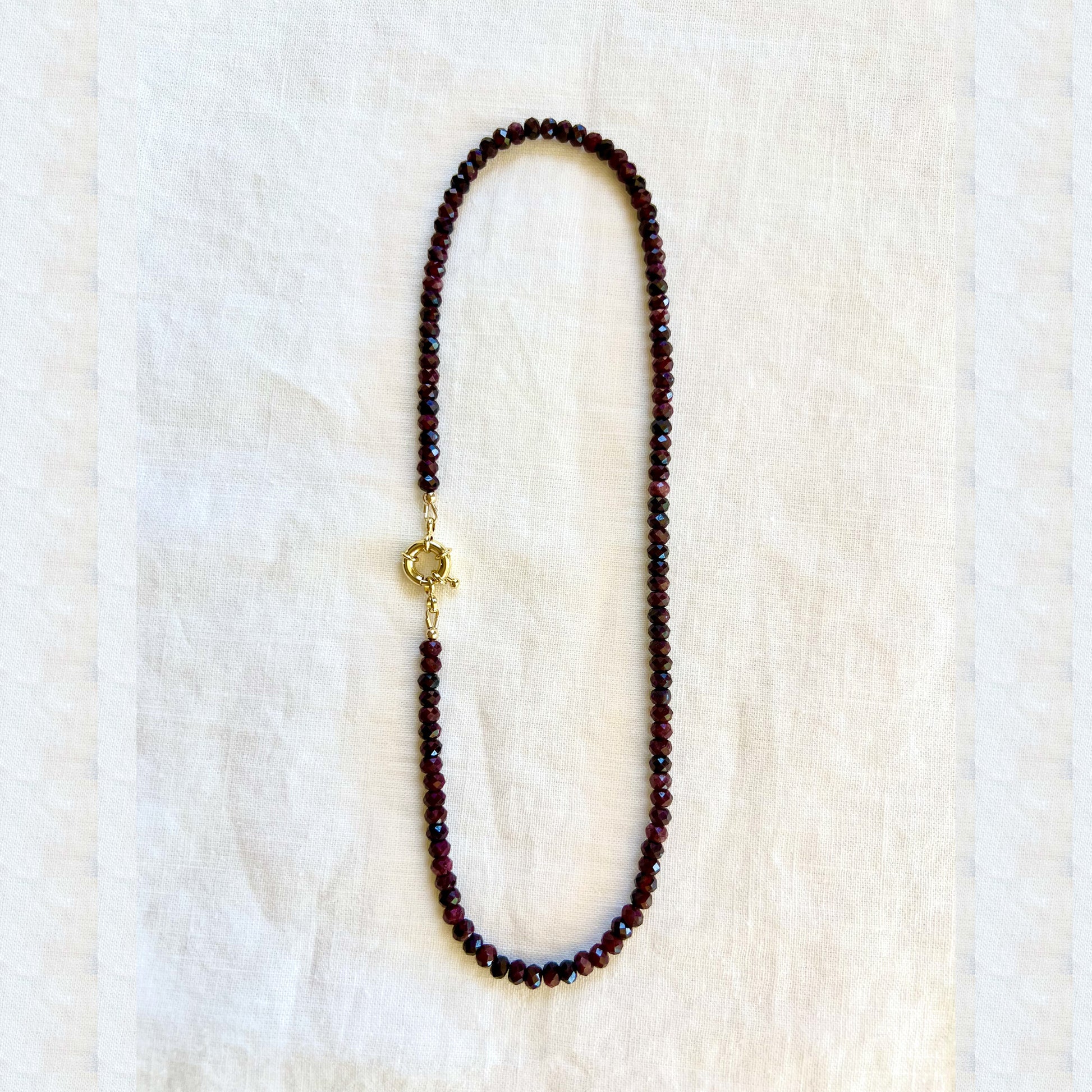 The garnet strand with the flower pendant removed, showing the gold filled clasp worn on its own
