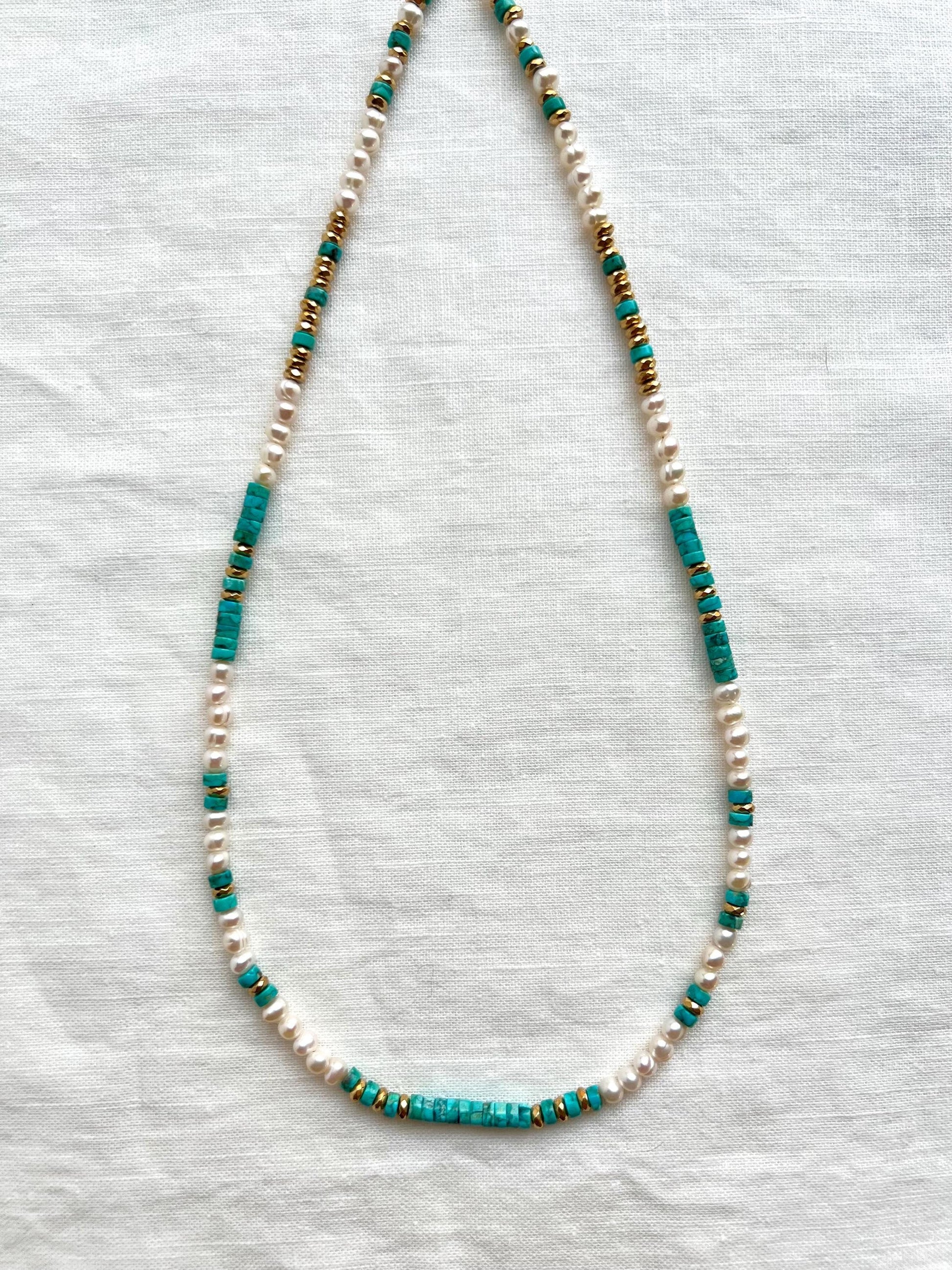 Full length view of the 18 inch strand showing the pattern of Arizona turquoise heishi, round white freshwater pearls and gold plated hematite spacers.