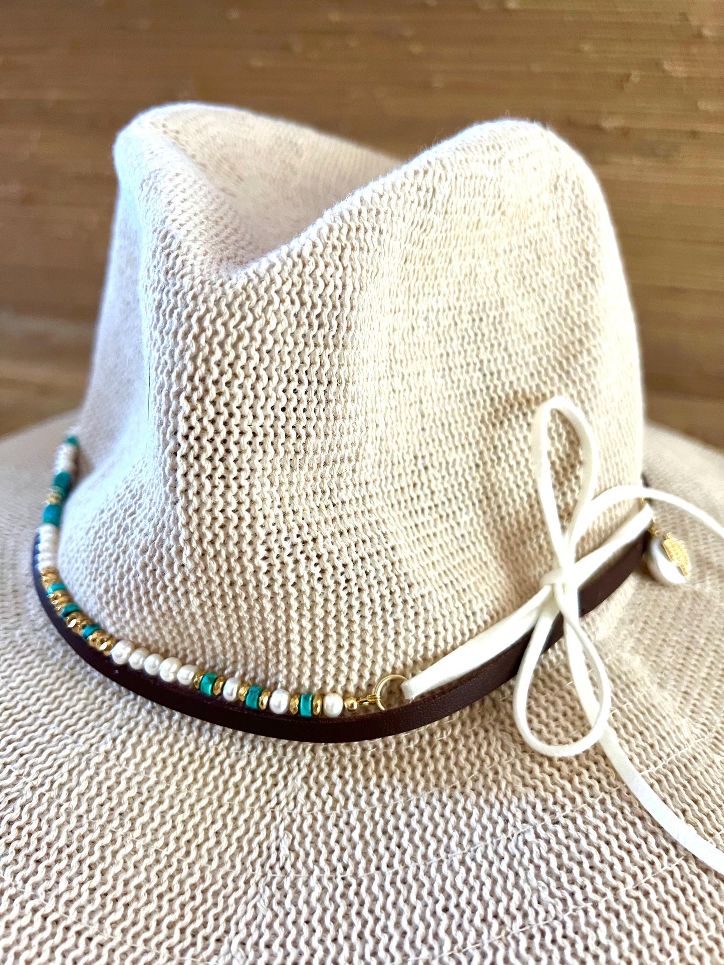 Cream woven hat with the Arizona turquoise and pearl band around the crown and the long suede ties left hanging loose.