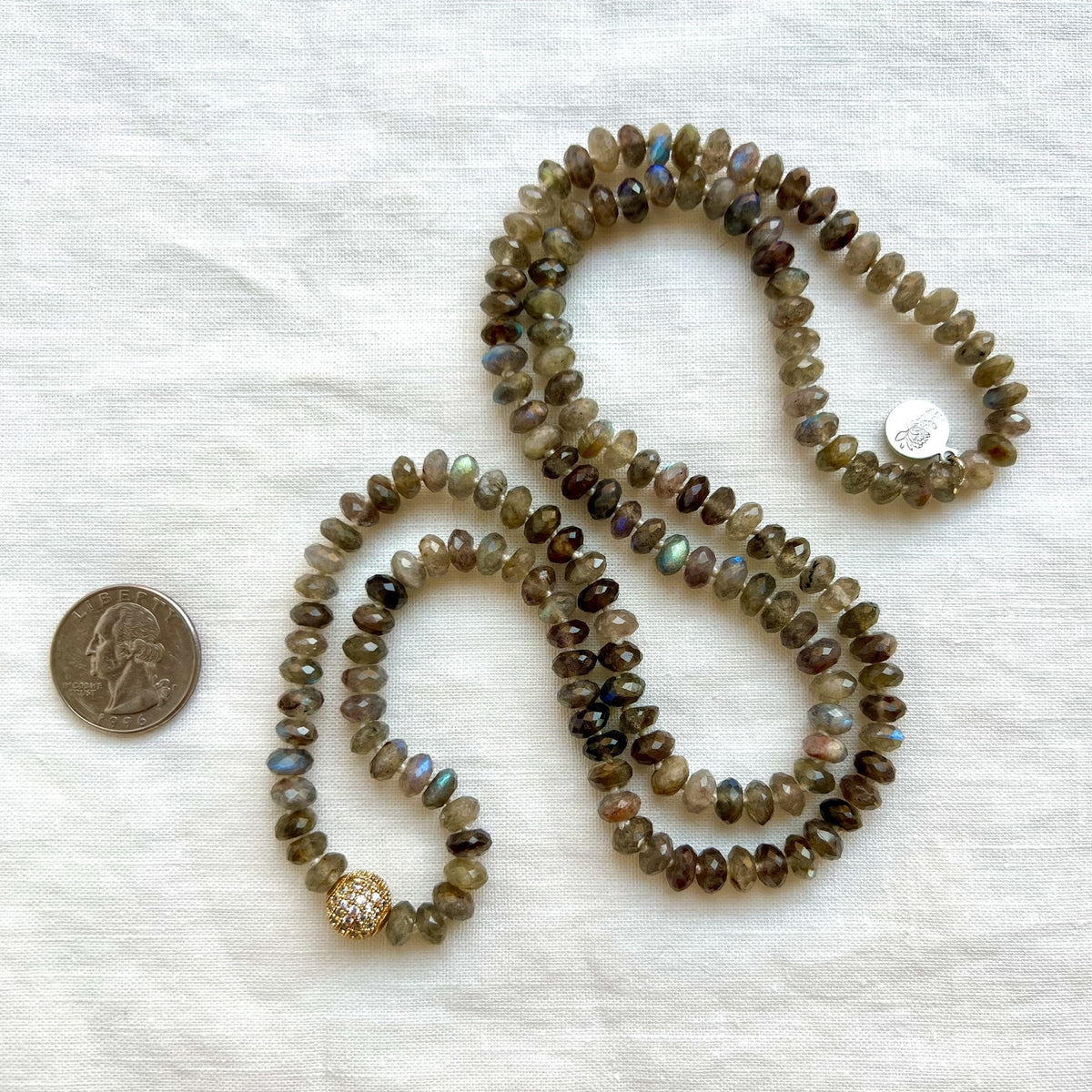 Emberlight faceted labradorite mala shown next to a quarter for scale