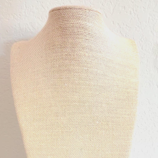 Video of the garnet choker necklace and its carved conch shell flower pendant on a linen display form