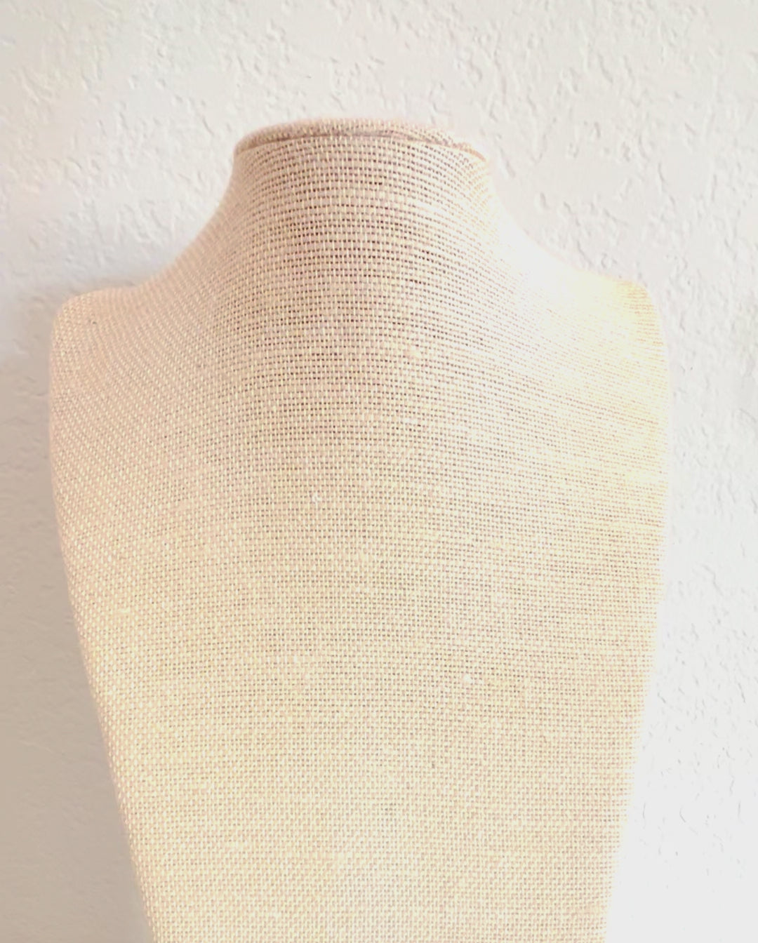 Video of the garnet choker necklace and its carved conch shell flower pendant on a linen display form