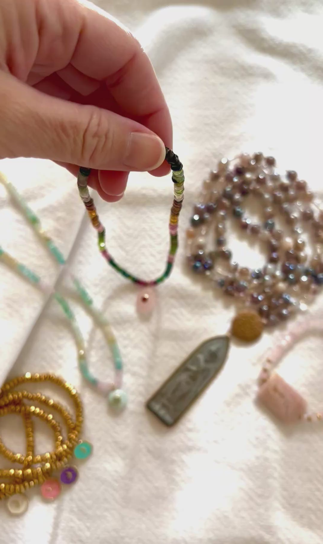Video of the ombre tourmaline necklace turning in the light to show the pink, green and blue beads and the rose quartz and garnet pendant