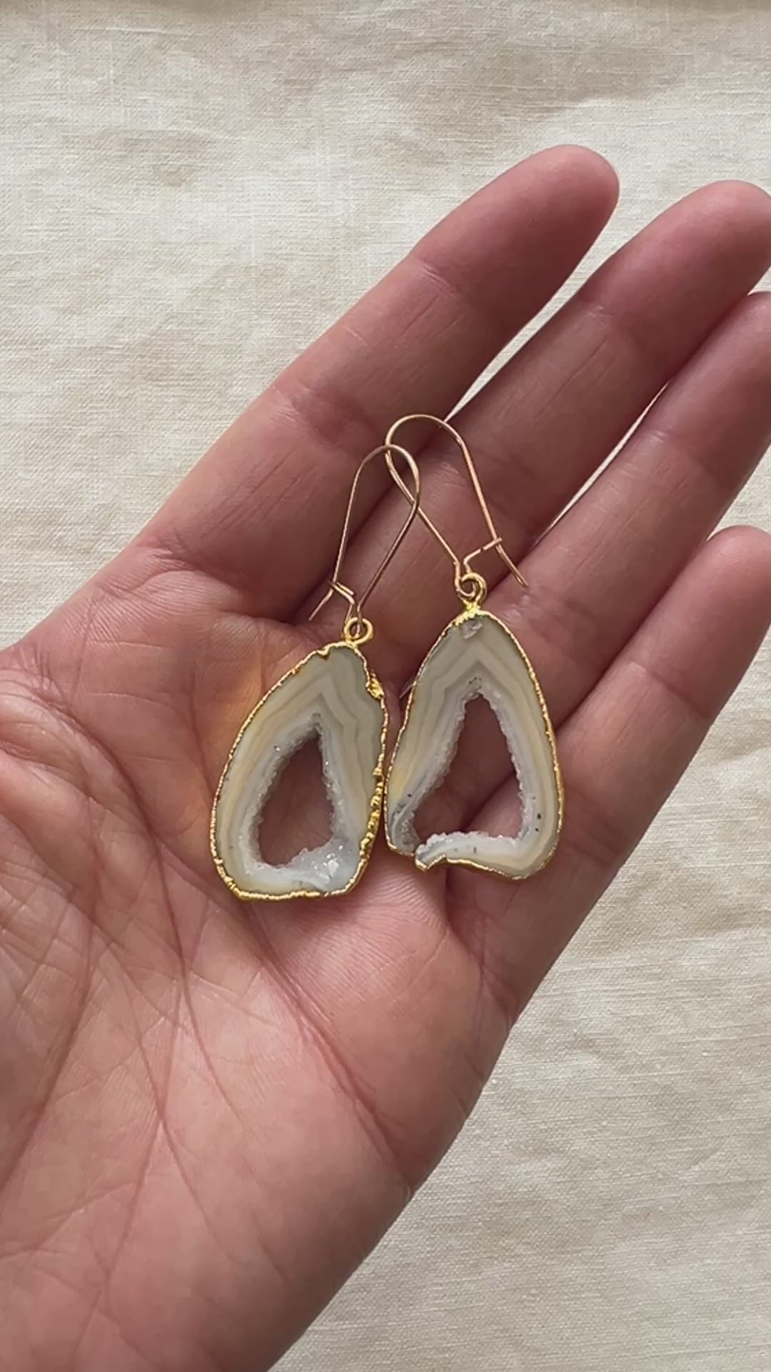 Video of the grey open geode agate slice earrings turning in the light