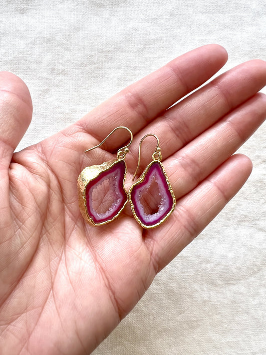 Pink agate slice geode earrings held in an open palm, showing how large the slices are