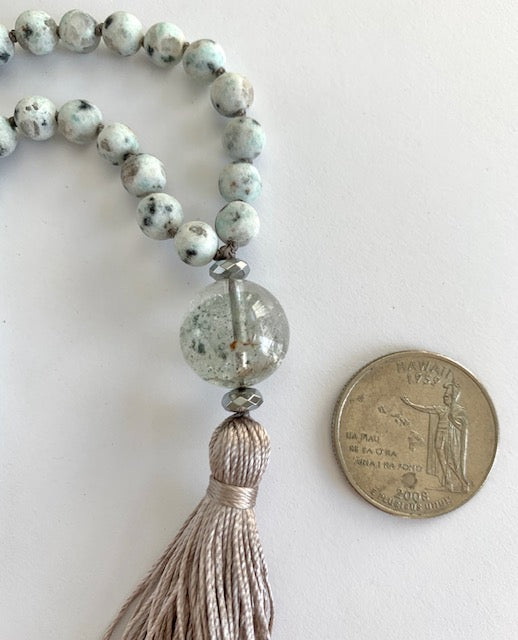 Kiwi Jasper Mala Beads next to a quarter for size comparison