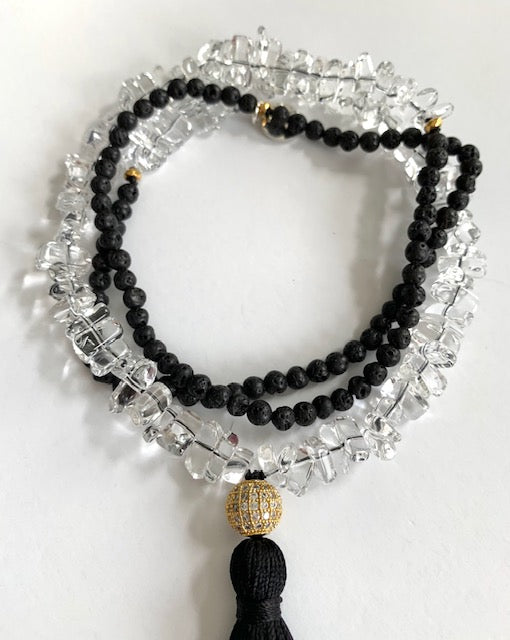 Tassel necklace with clear quartz and black lava beads, pave cz gold plated guru bead, black silk tassel, close up detail