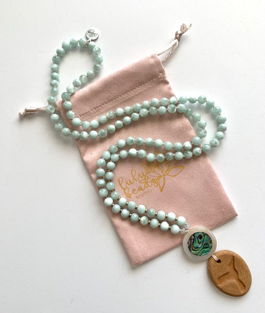green Angelite mala necklace with mother of pearl guru bead and hummingbird oil diffuser pendant with lulu beads studio pink pouch