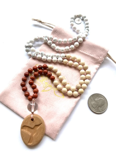 mala necklace, 6mm red jasper, riverstone, and howlite jasper, quartz guru bead and terra cotta hummingbird oil diffuser amulet with us quarter for size comparison