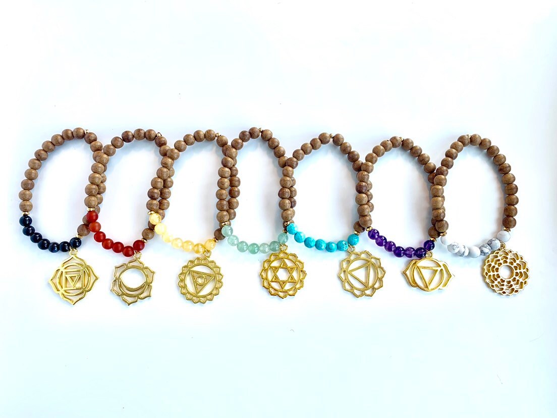 group of chakra balancing bracelets made of sandalwood with multi gemstones