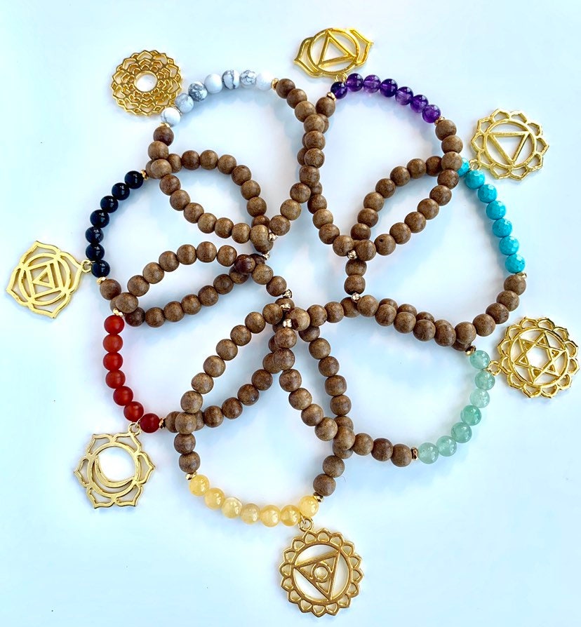 grouping of chakra bracelets made of sandalwood and multi gemstones