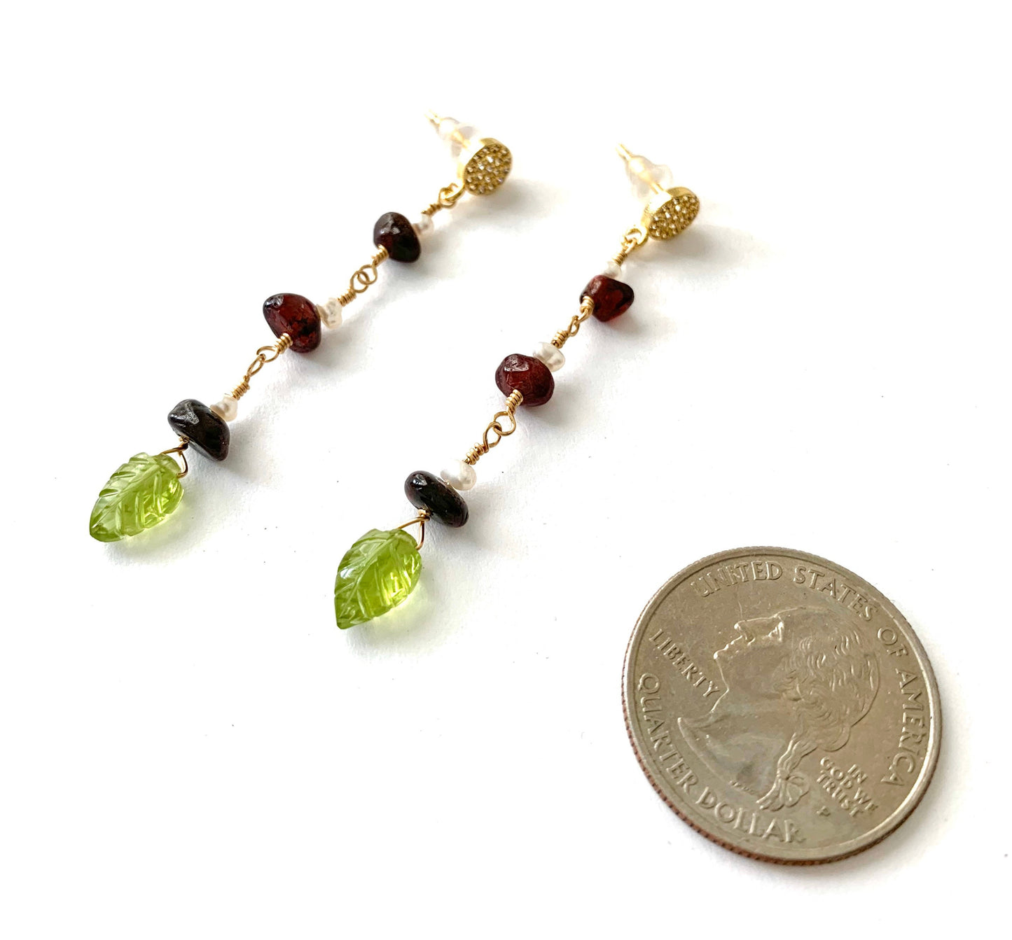 yellow gold filled dangle earring with pave' cz round studs and 3 garnet and pearl stations suspended from chain. carved peridot leaves hang from the bottom.  