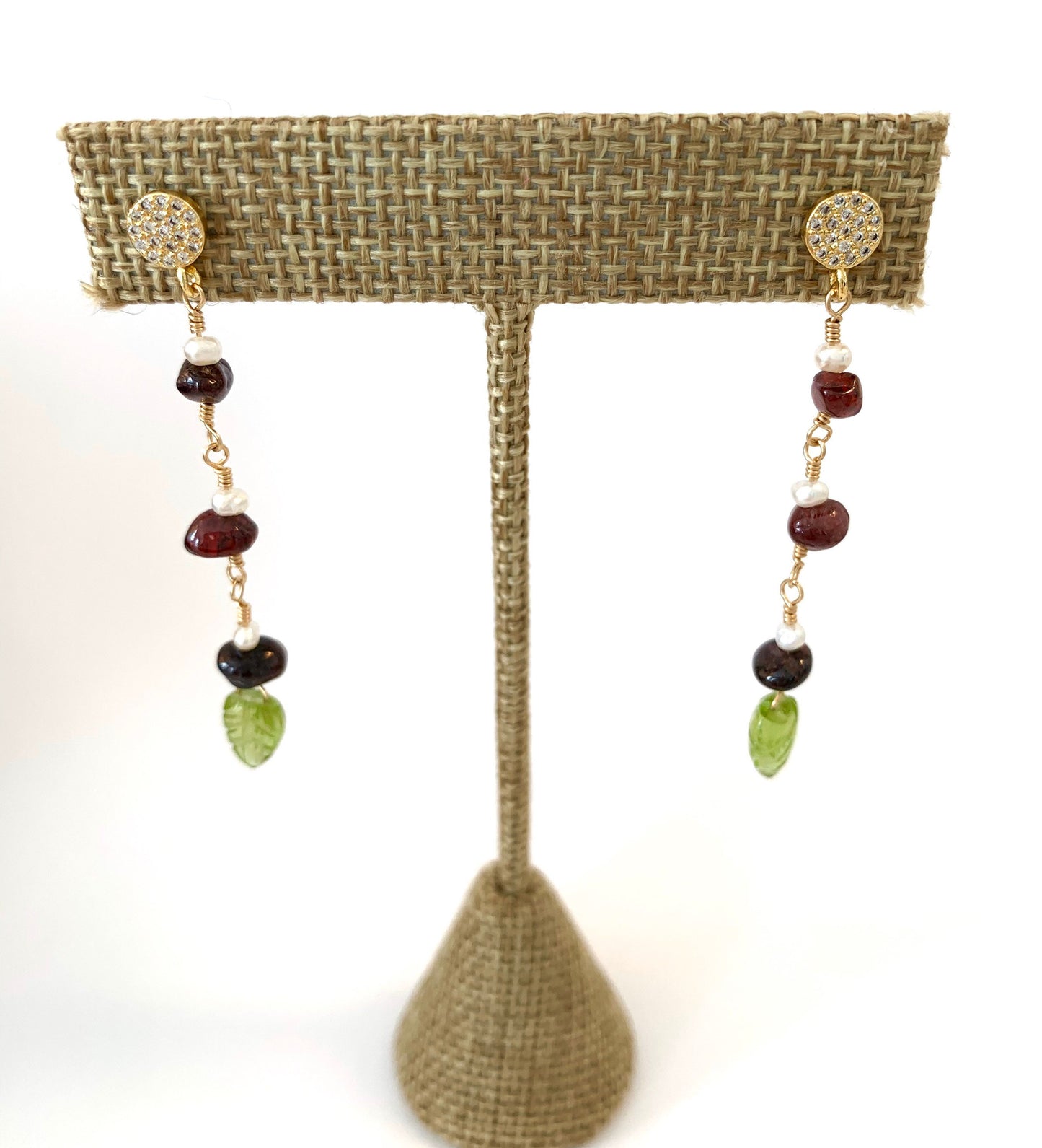 yellow gold filled dangle earring with pave' cz round studs and 3 garnet and pearl stations suspended from chain.  carved peridot leaves hang from the bottom.